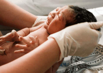 new born in midwife hands